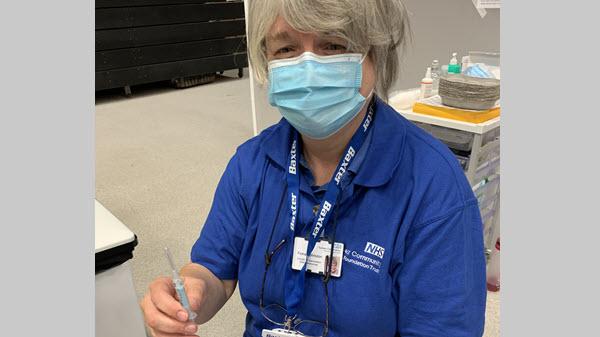Baxter employee holds a syringe in a clinical environment